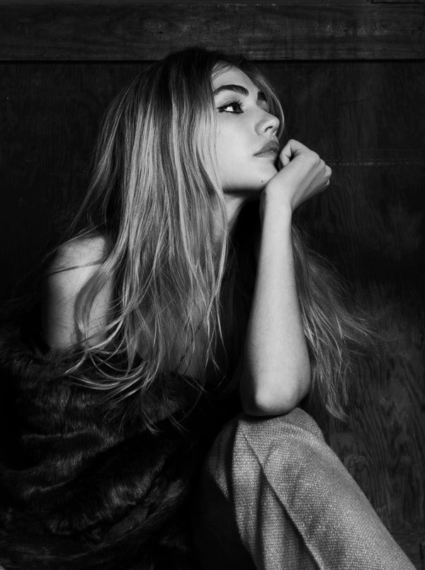 provocative woman sitting with chin resting on palm