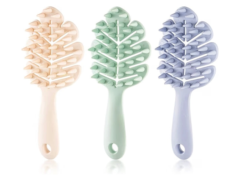 Three leaf shaped scalp stimulator brushes on a white background