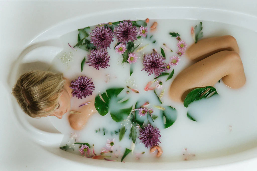 woman taking a milk bath with flowers