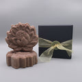 Dark pink Shampoo Bar sitting next to a black box with gold ribbon