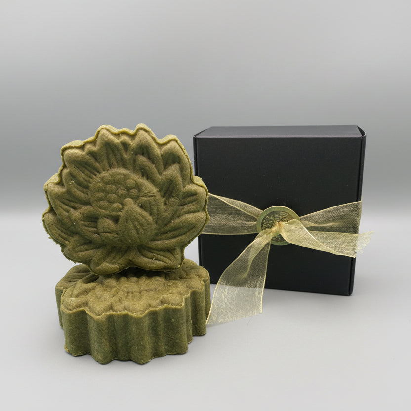 Green lotus shaped shampoo bars with a black box and gold ribbon 