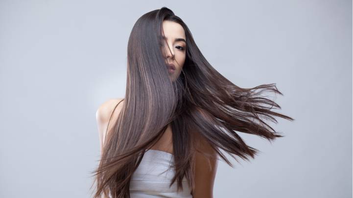 Woman with long, flowing hair against a plain background