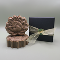 Brown shampoo bar with black box wrapped in gold ribbon