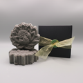 Blue oily hair Shampoo Bar sitting next to a black box with gold ribbon