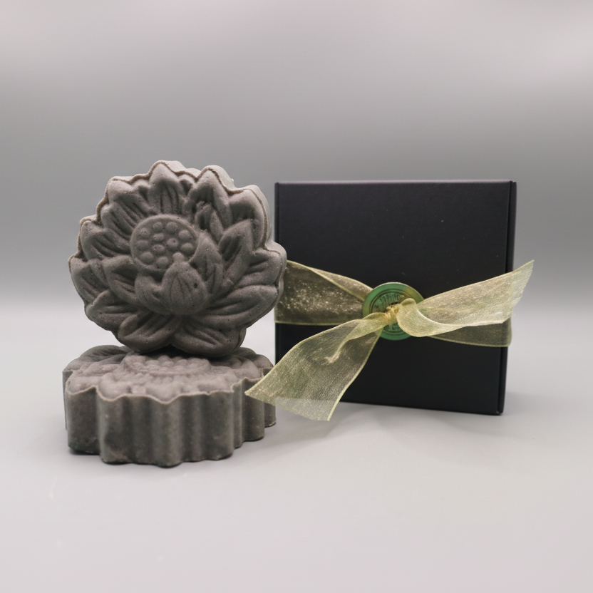 Blue oily hair Shampoo Bar sitting next to a black box with gold ribbon