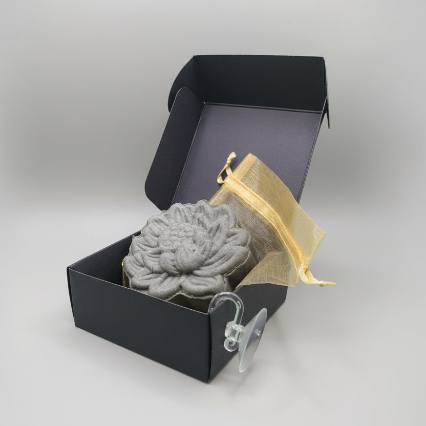 Blue oily hair Shampoo Bar sitting next to a black box with gold ribbon