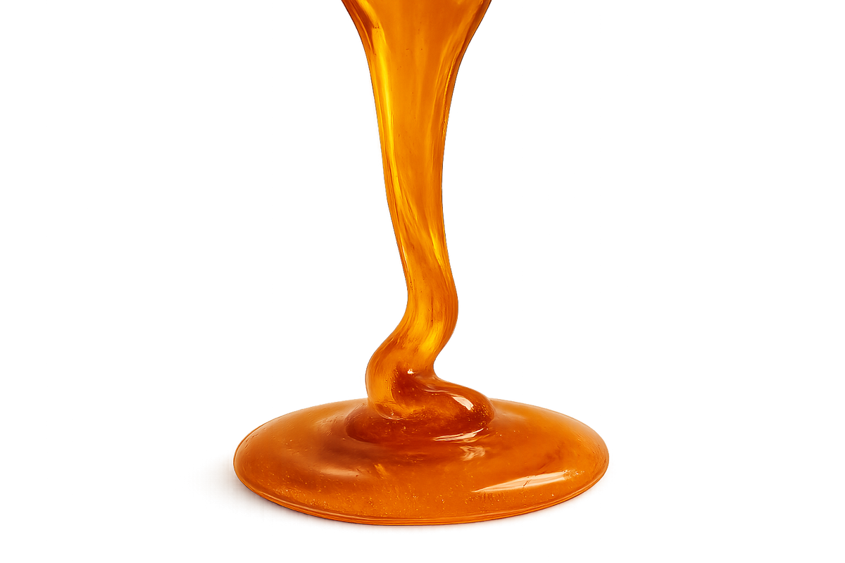 stream of manuka honey pouring into a small pool of manuka honey with transparent background